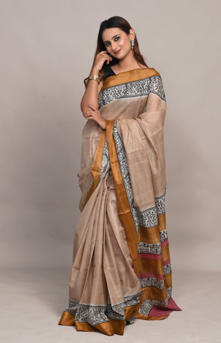 Model wearing Kosakari Mridulika beige blended Kosa silk hand block printed saree with tribal motifs and golden border.