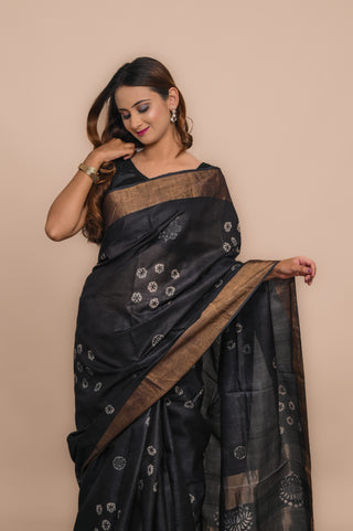 Model wearing Kosakari Chandrika Charcoal Blended Kosa silk hand block printed saree with floral motifs and elegant border.